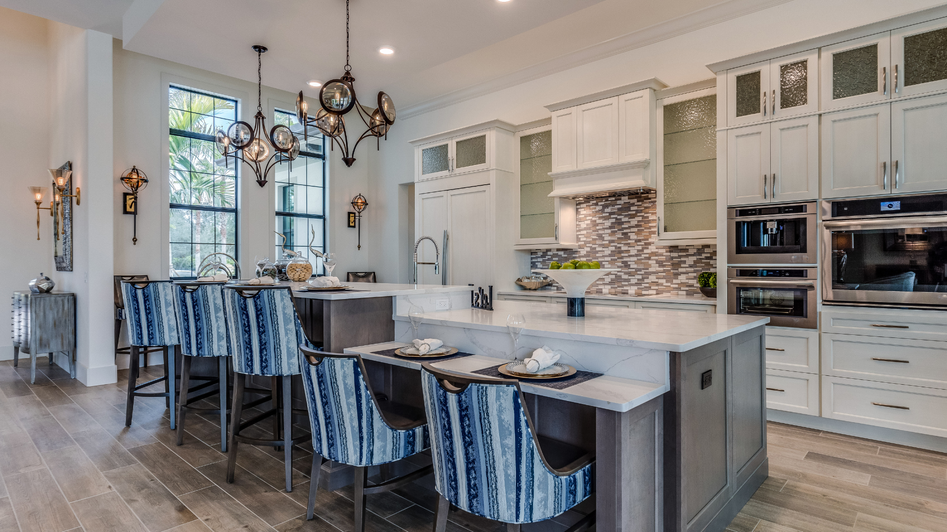 A kitchen with white cabinets , stainless steel appliances , and a large island.