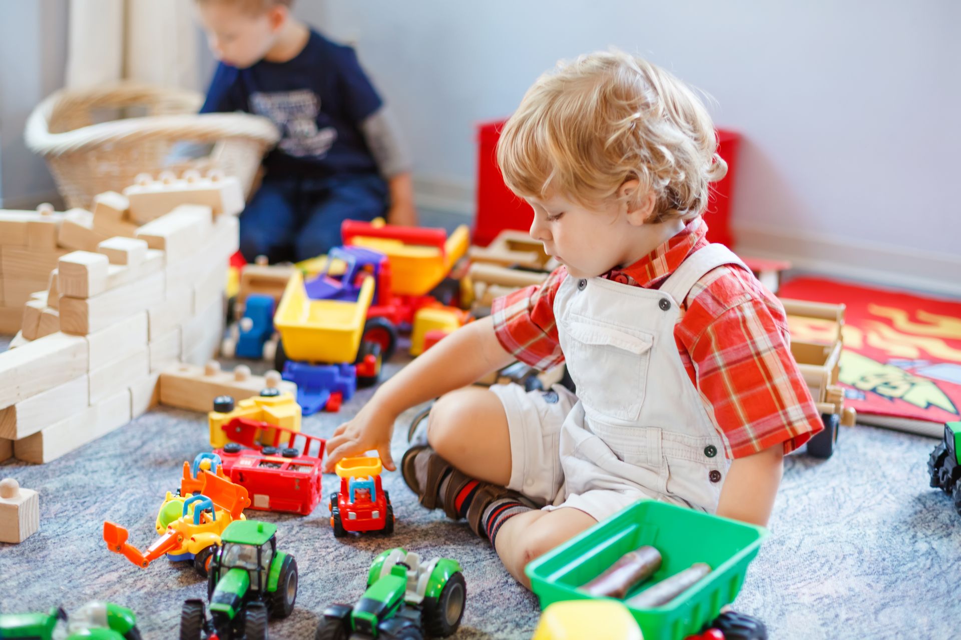 A young boy is sitting on the floor playing with toys.