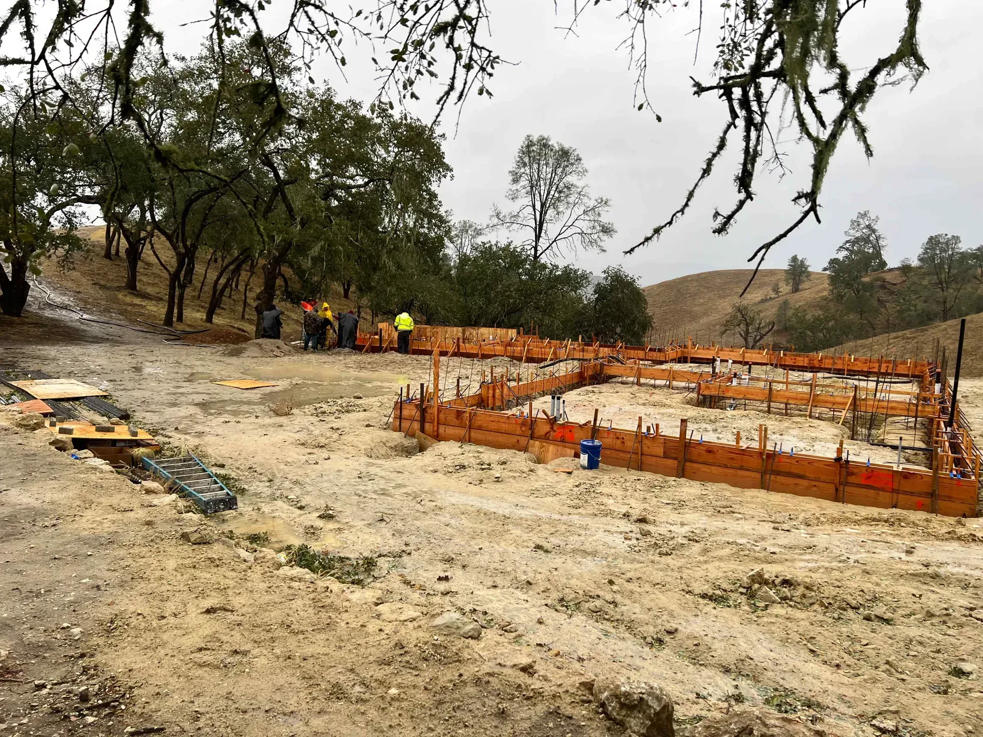 A group of construction workers are standing in a dirt field.