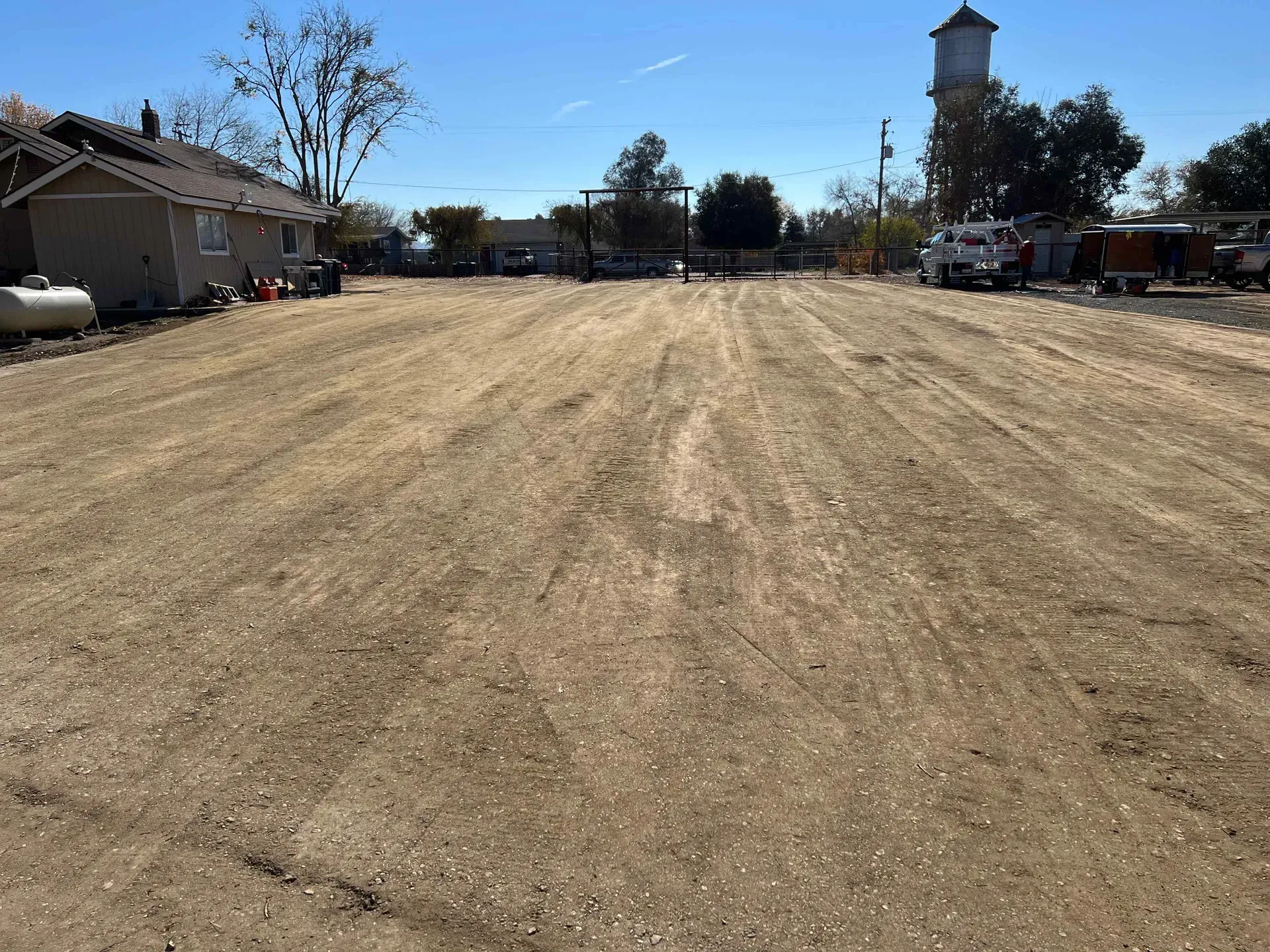 A dirt road with a water tower in the background