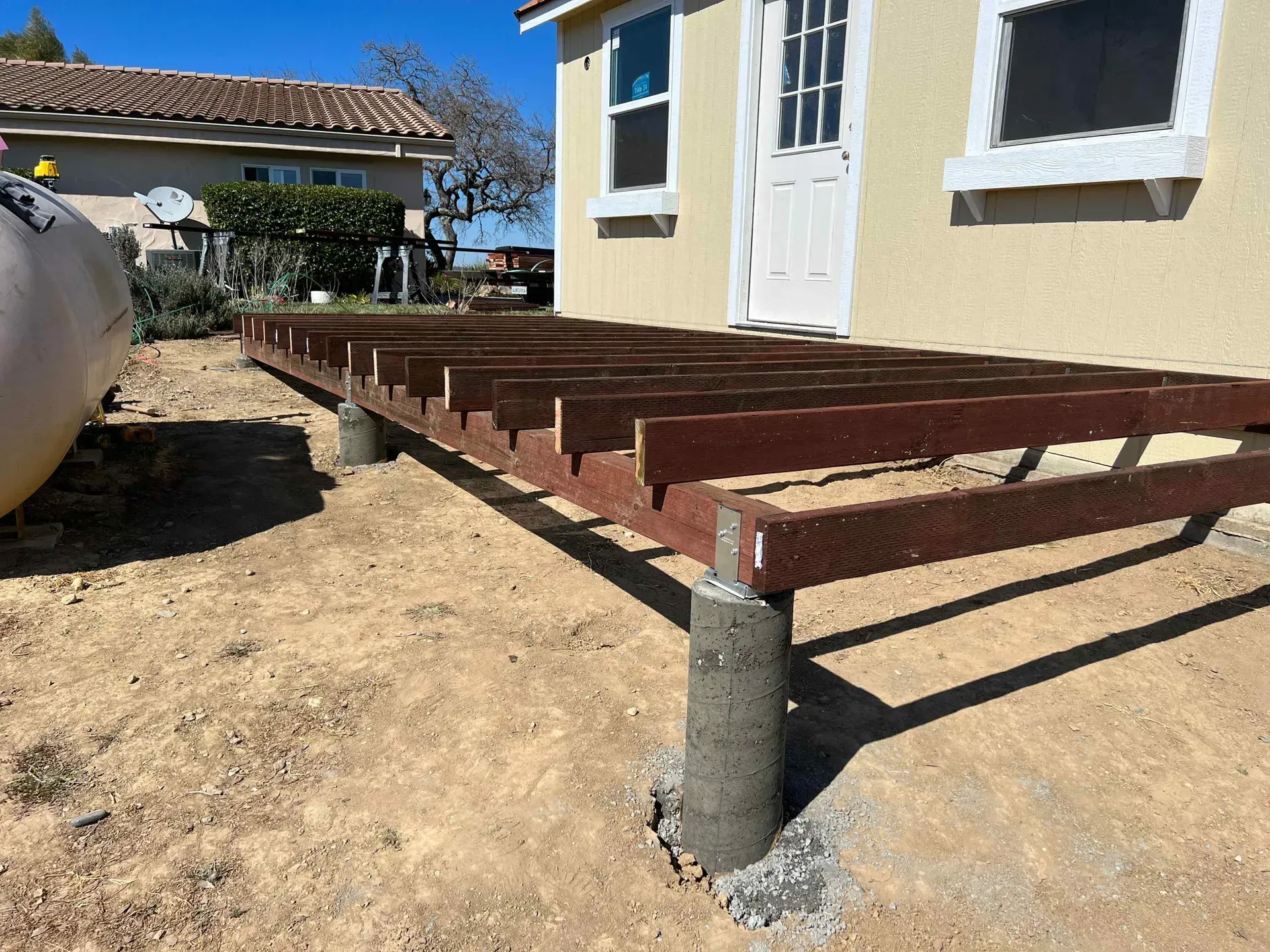 A wooden deck is being built in front of a house