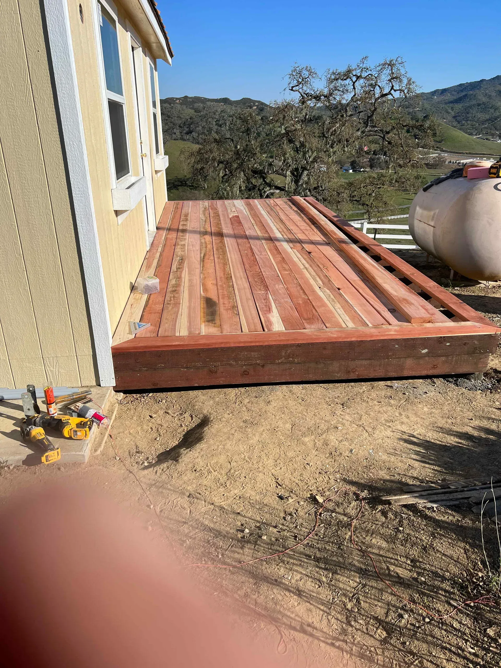 A wooden deck is being built on the side of a house.