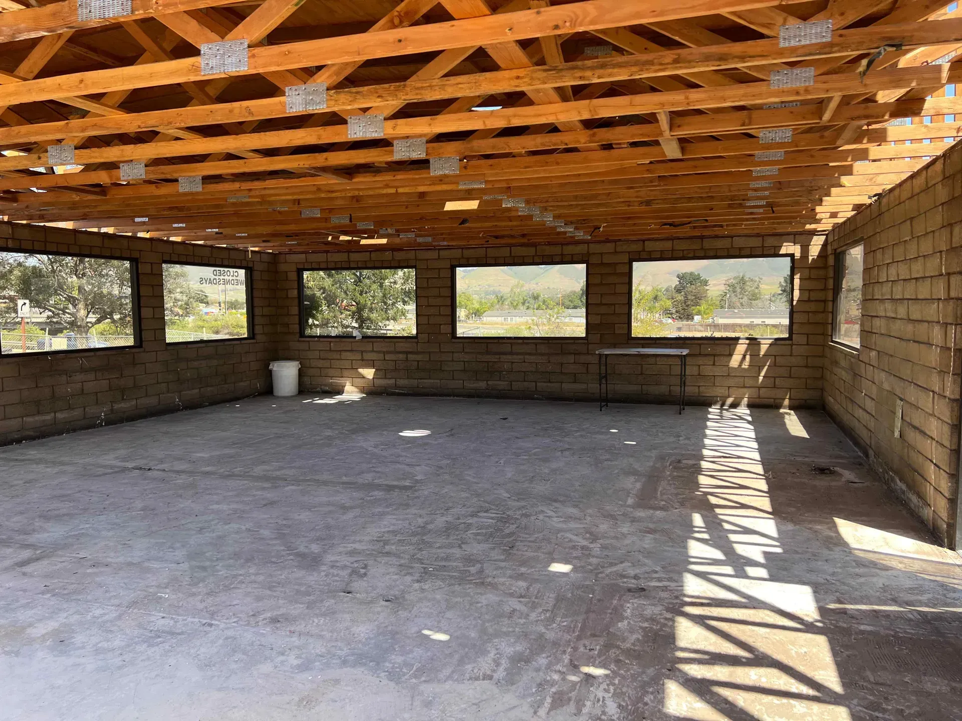 A large empty room with a wooden roof and brick walls.