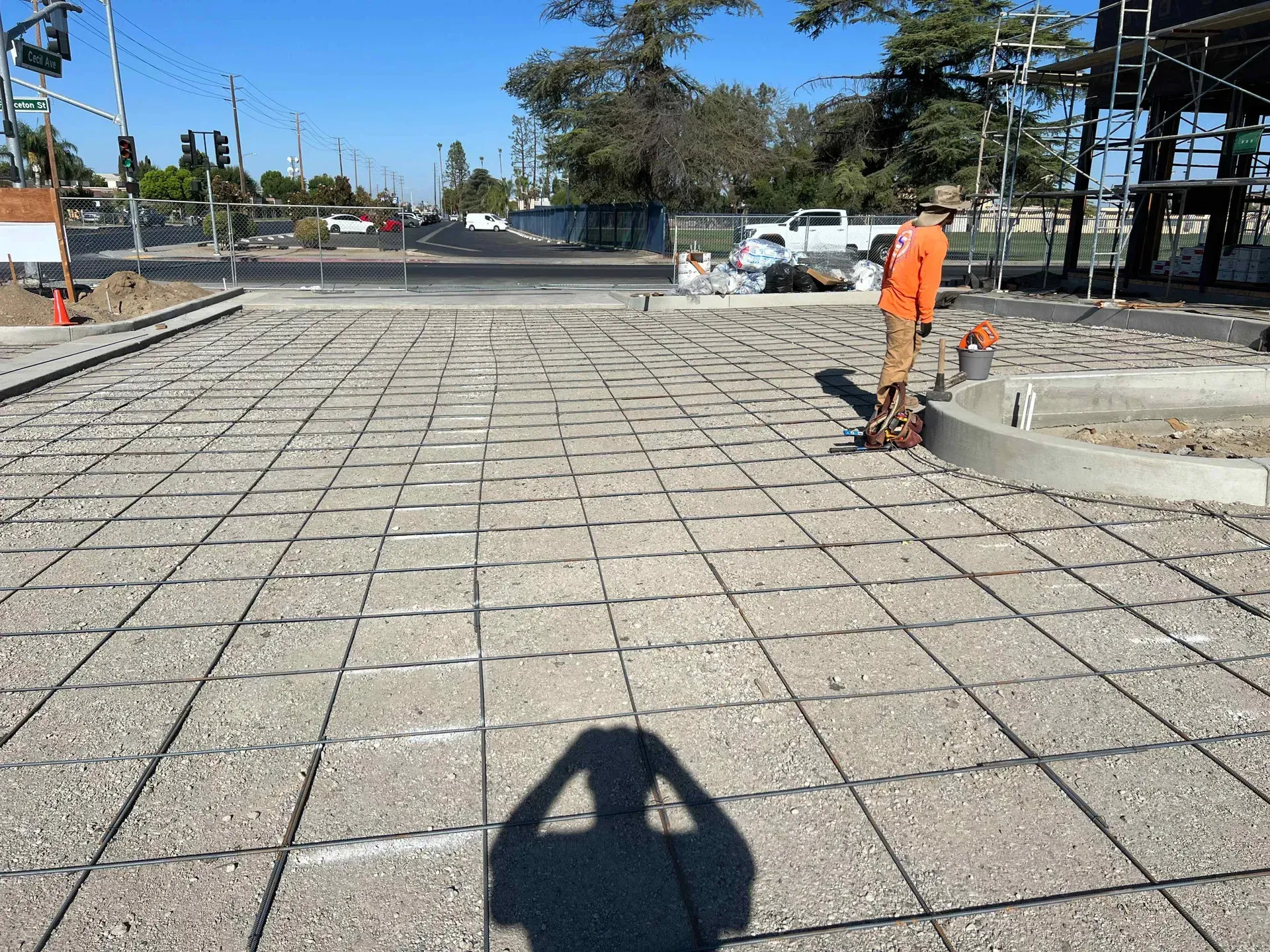 A man is standing on a concrete floor with his shadow on the ground.
