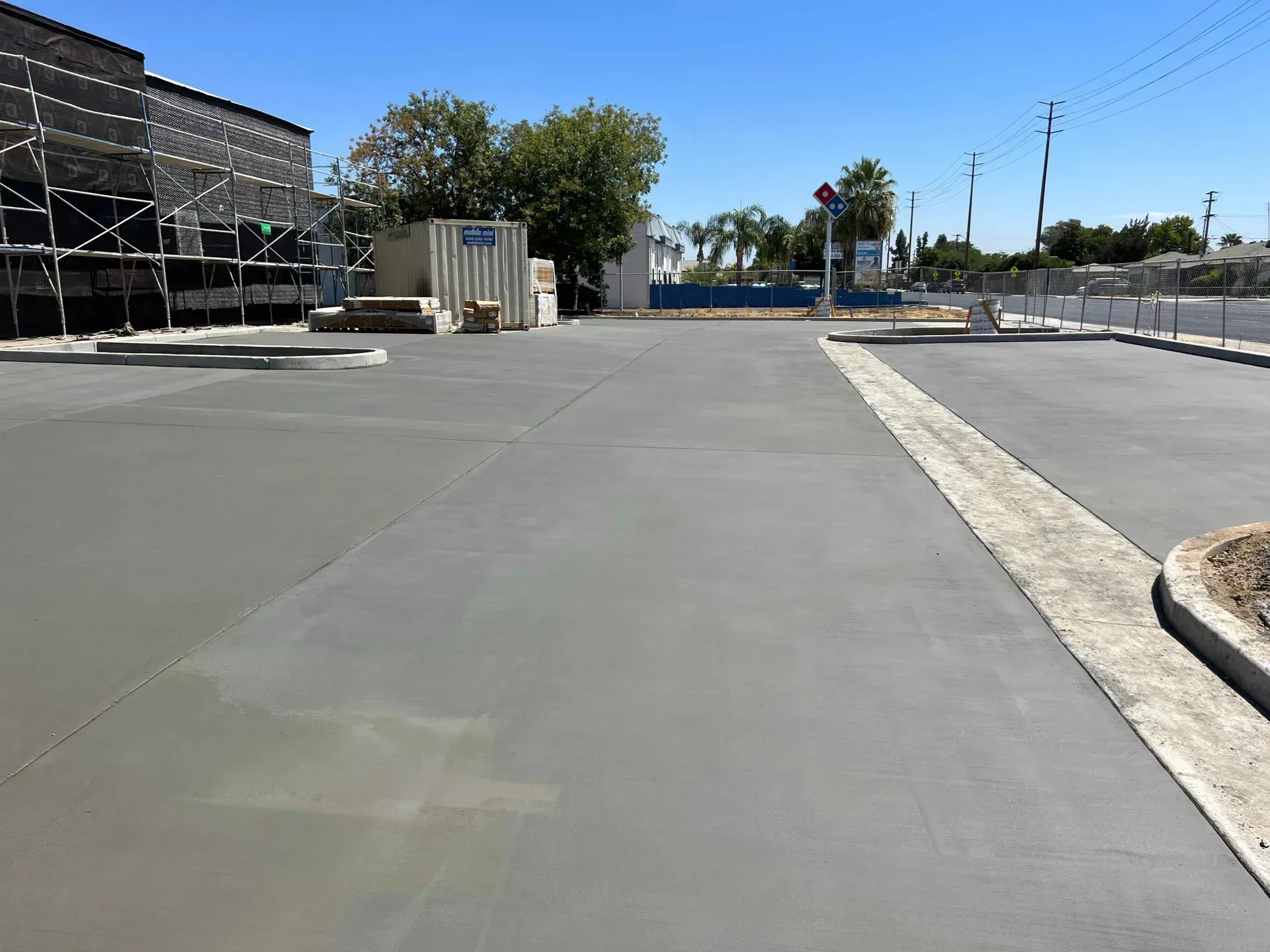 A concrete driveway with a building in the background