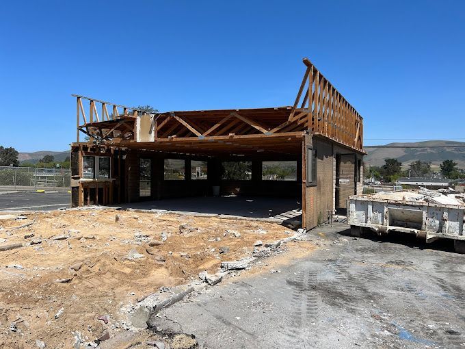 A building under construction with a dumpster in front of it