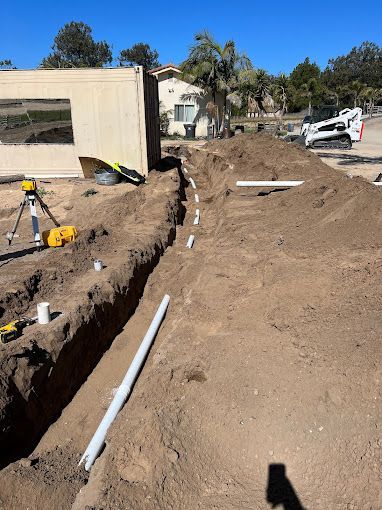 A construction site with pipes being installed in the dirt.