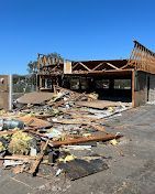 A large building is being demolished and there is a lot of rubble in front of it.