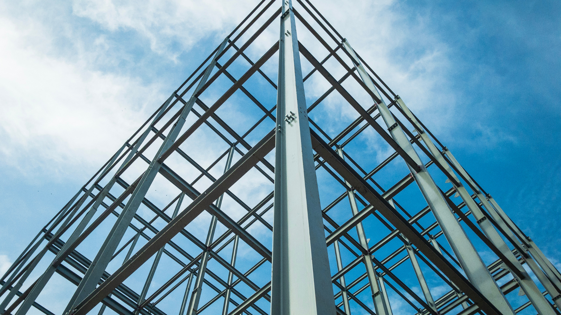 Looking up at a building under construction with a blue sky in the background.