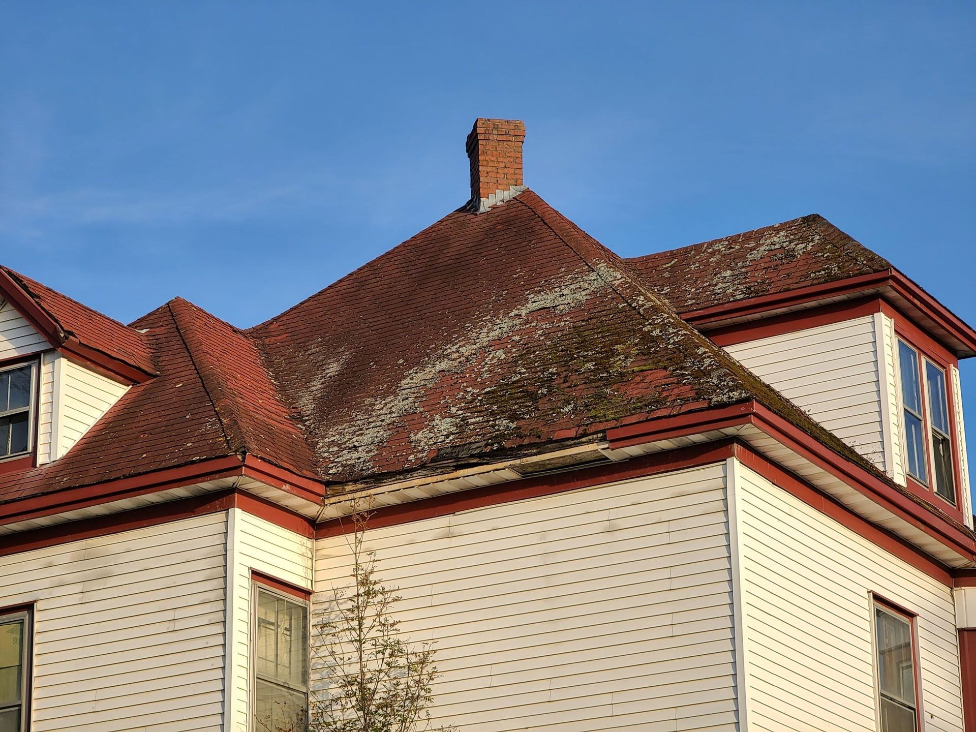 A white house with a red roof and a chimney