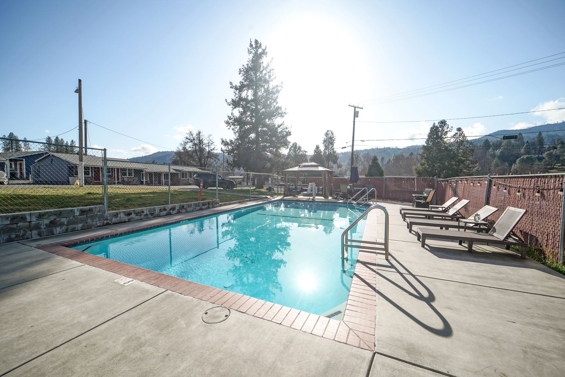 Outdoor swimming pool with lounge chairs on a sunny day