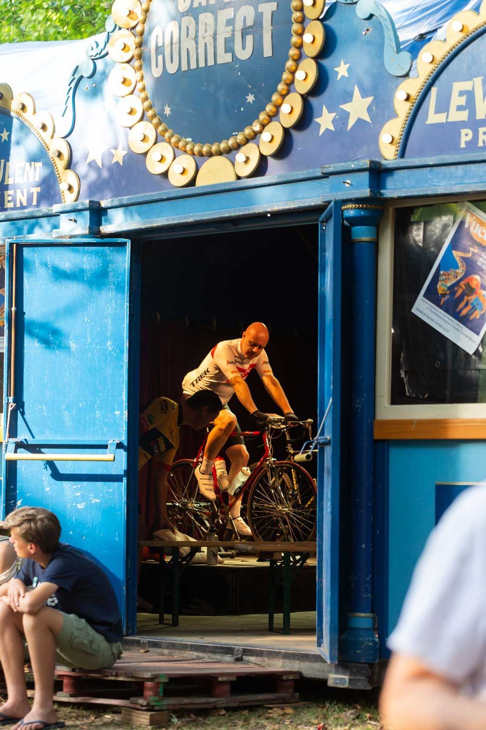 Een persoon op een fiets in een hokje met een 'Correct'-bordje erboven. Er zit iemand in de buurt.