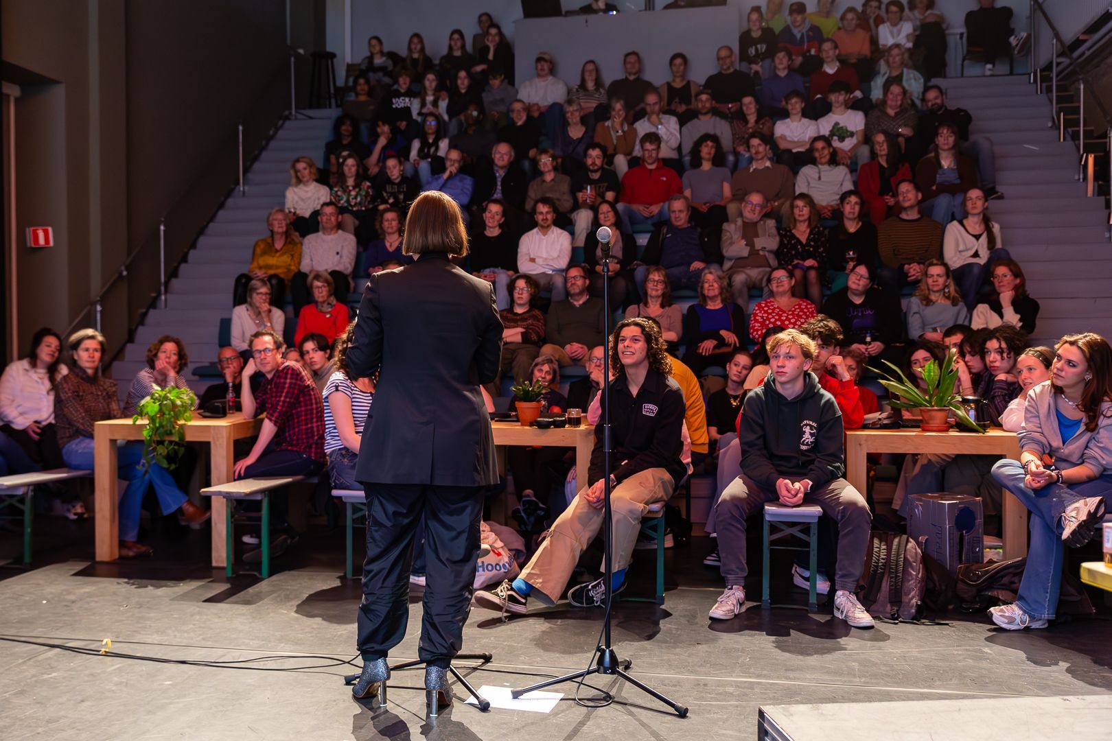 Een vrouw staat voor een microfoon voor een menigte