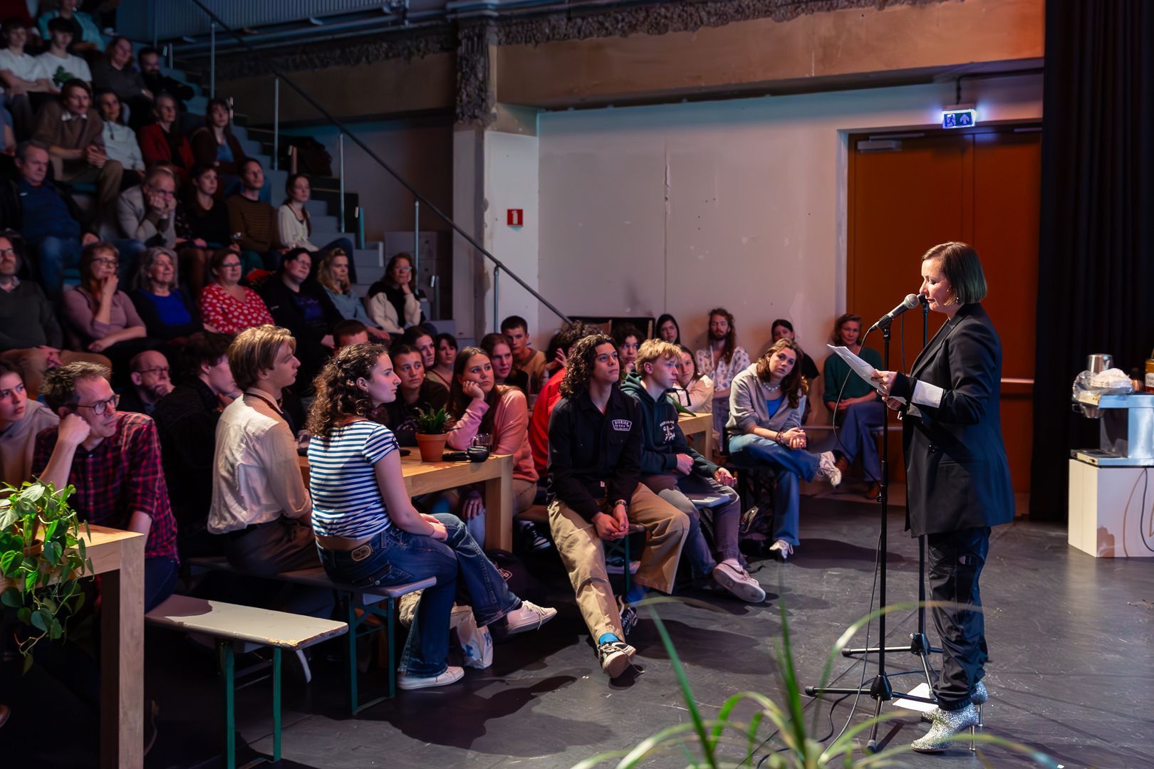 Een vrouw staat voor een microfoon voor een menigte mensen