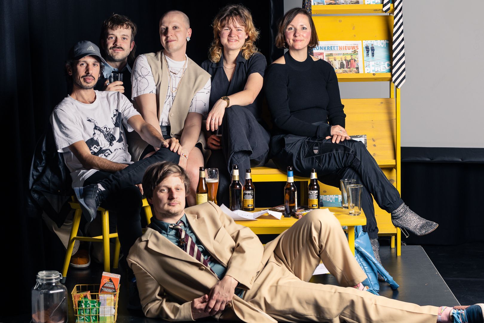 Een groep mensen poseert voor een foto met flesjes bier