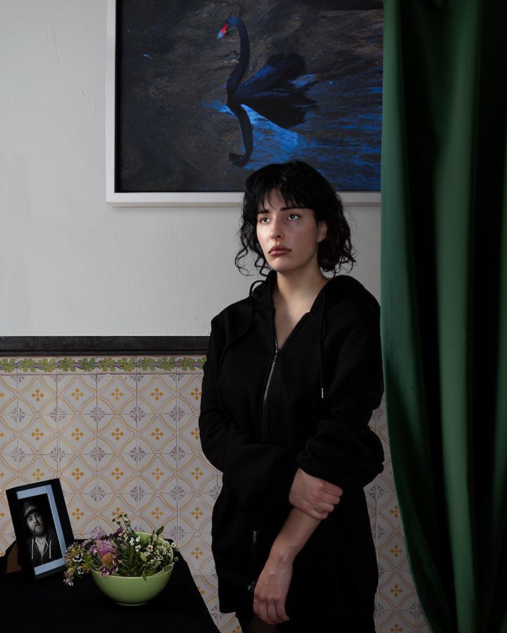 Een vrouw staat voor een schilderij van een zwarte zwaan