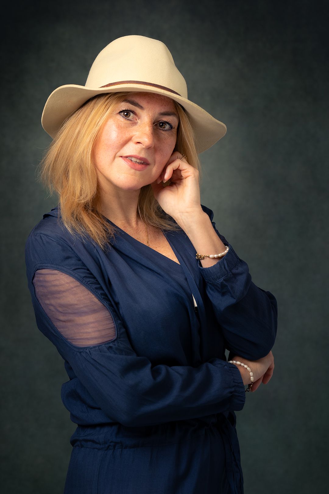 Een vrouw in een blauwe jurk en een witte hoed