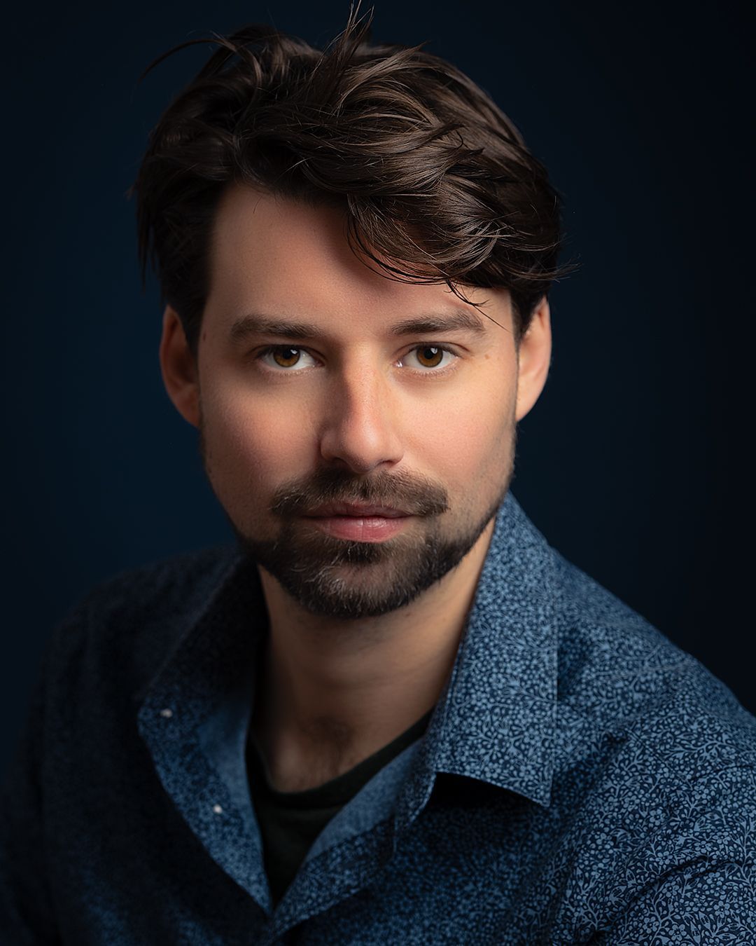 Cemme Steenhuisen met een baard draagt een blauw shirt en poseert voor een studioportret