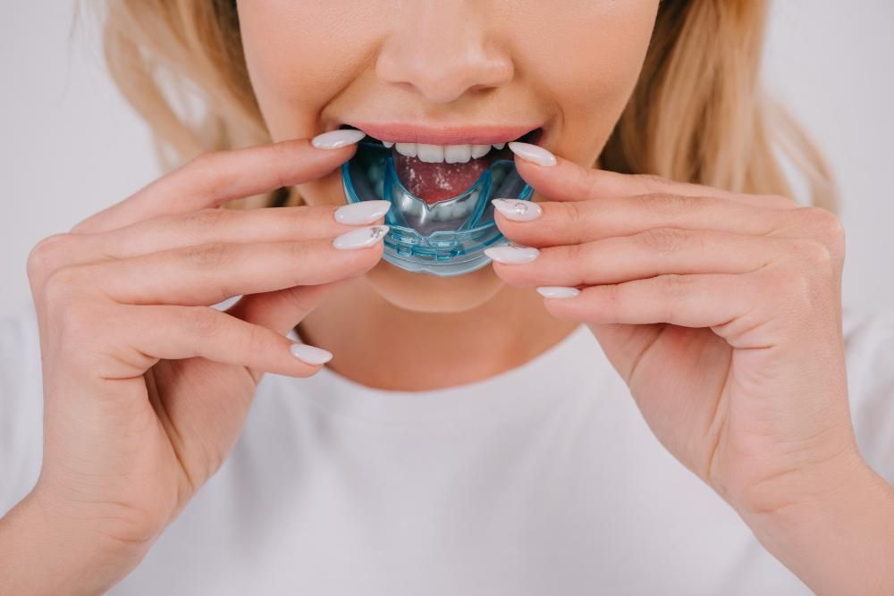 woman putting in a mouthguard 