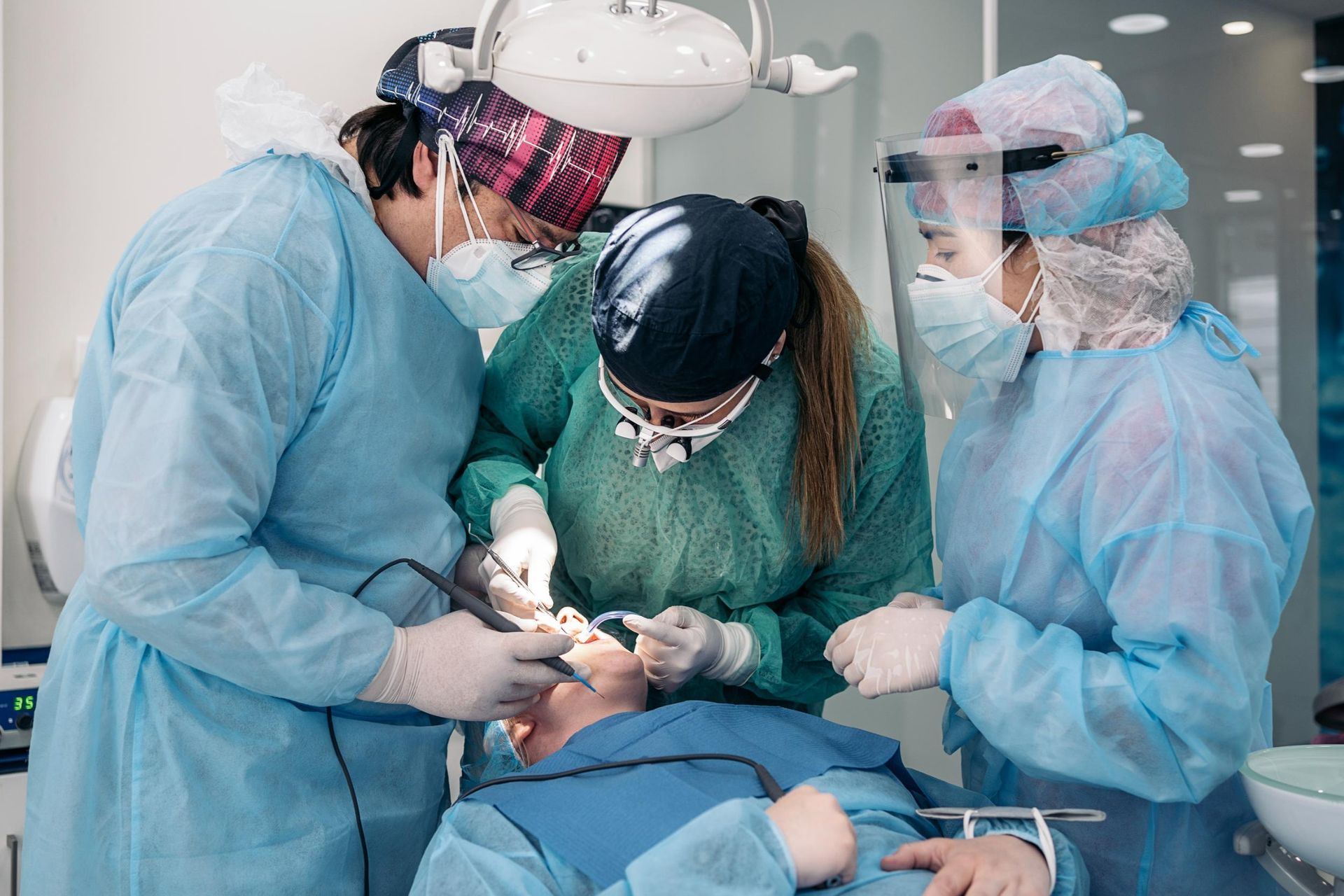 emergency dentists working on a patient 's teeth in a dental office.