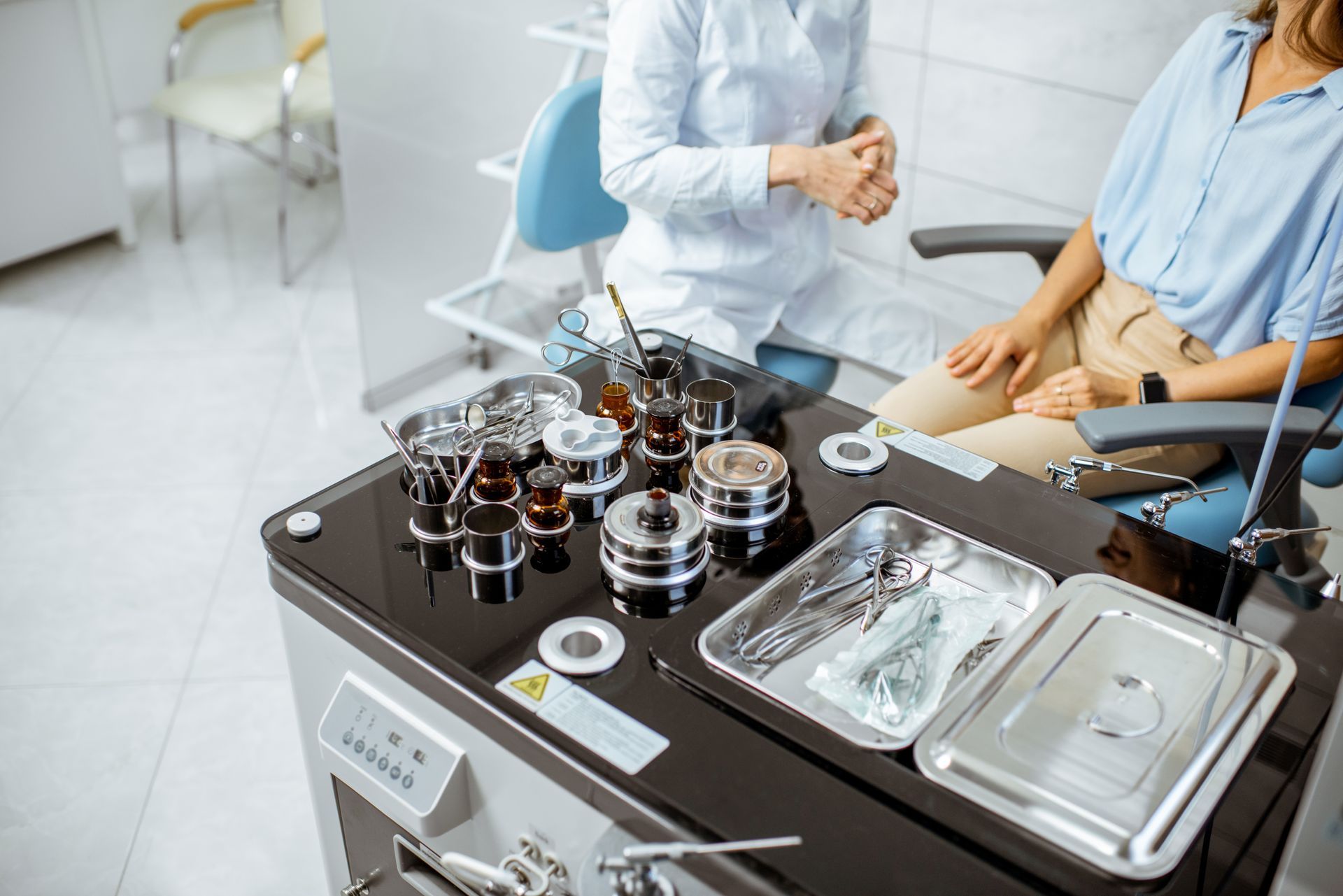 A woman is sitting in a dental chair talking to a dentist.