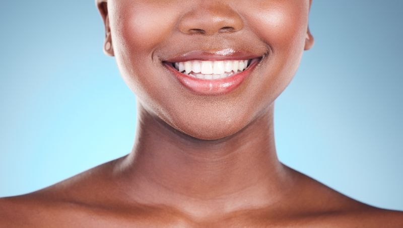 A close up of a woman 's face and neck smiling.