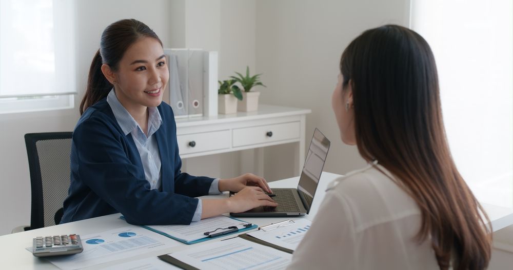 Woman in Navy Blazer  Having Meeting With Another Woman in an Office — People Assured Partners in Mackay, QLD