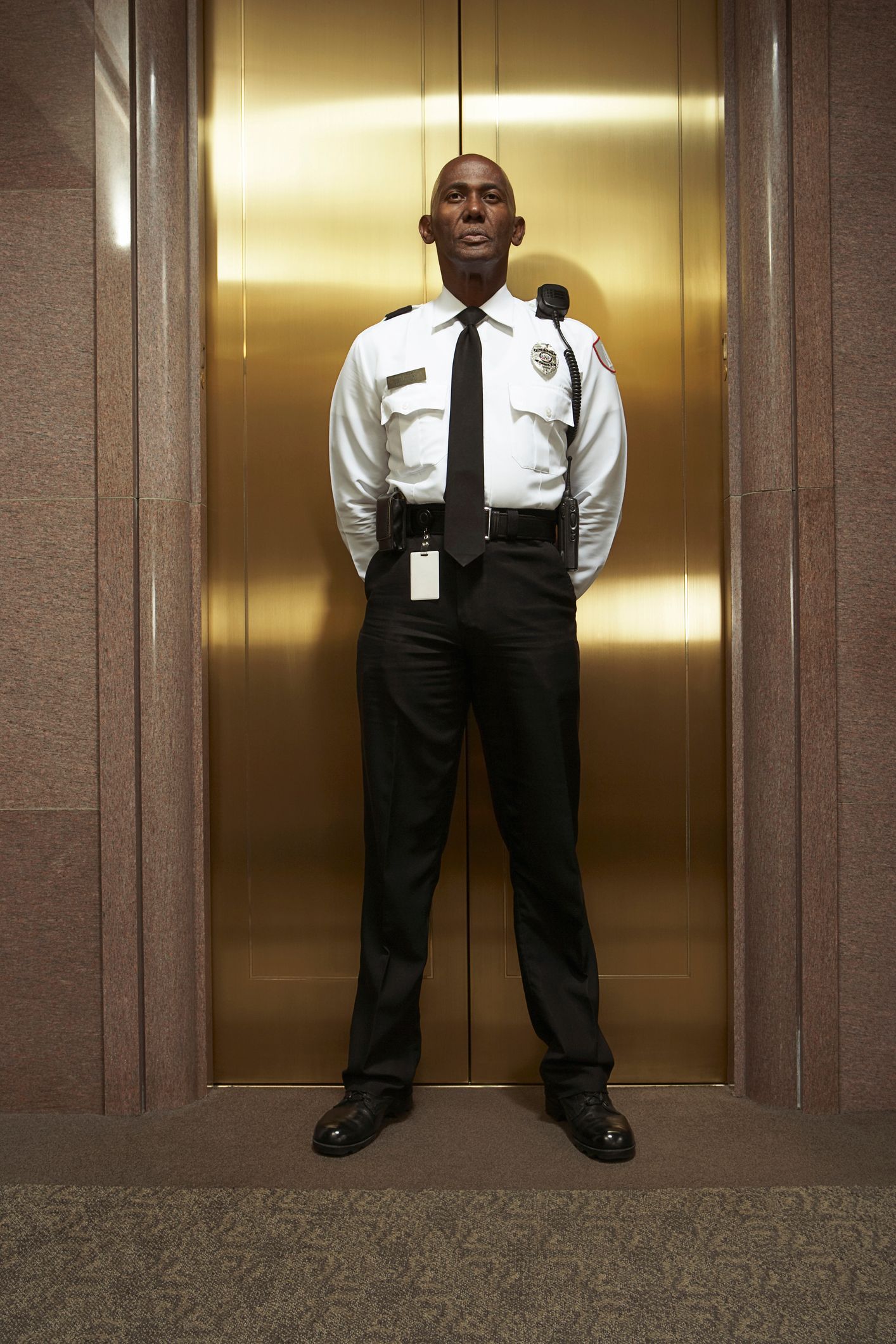 A security guard is standing in front of an elevator door