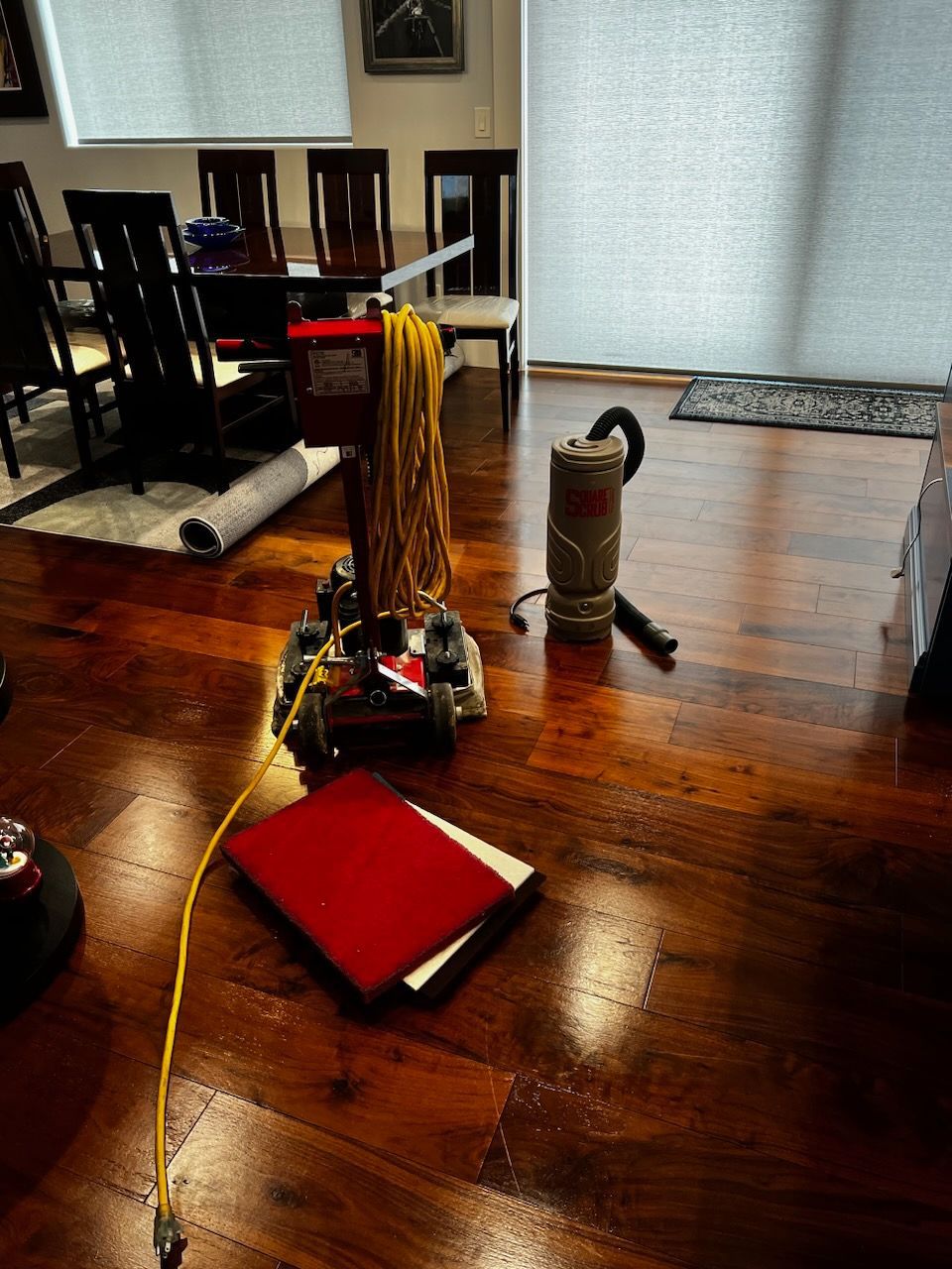 A vacuum cleaner is sitting on a wooden floor in a living room