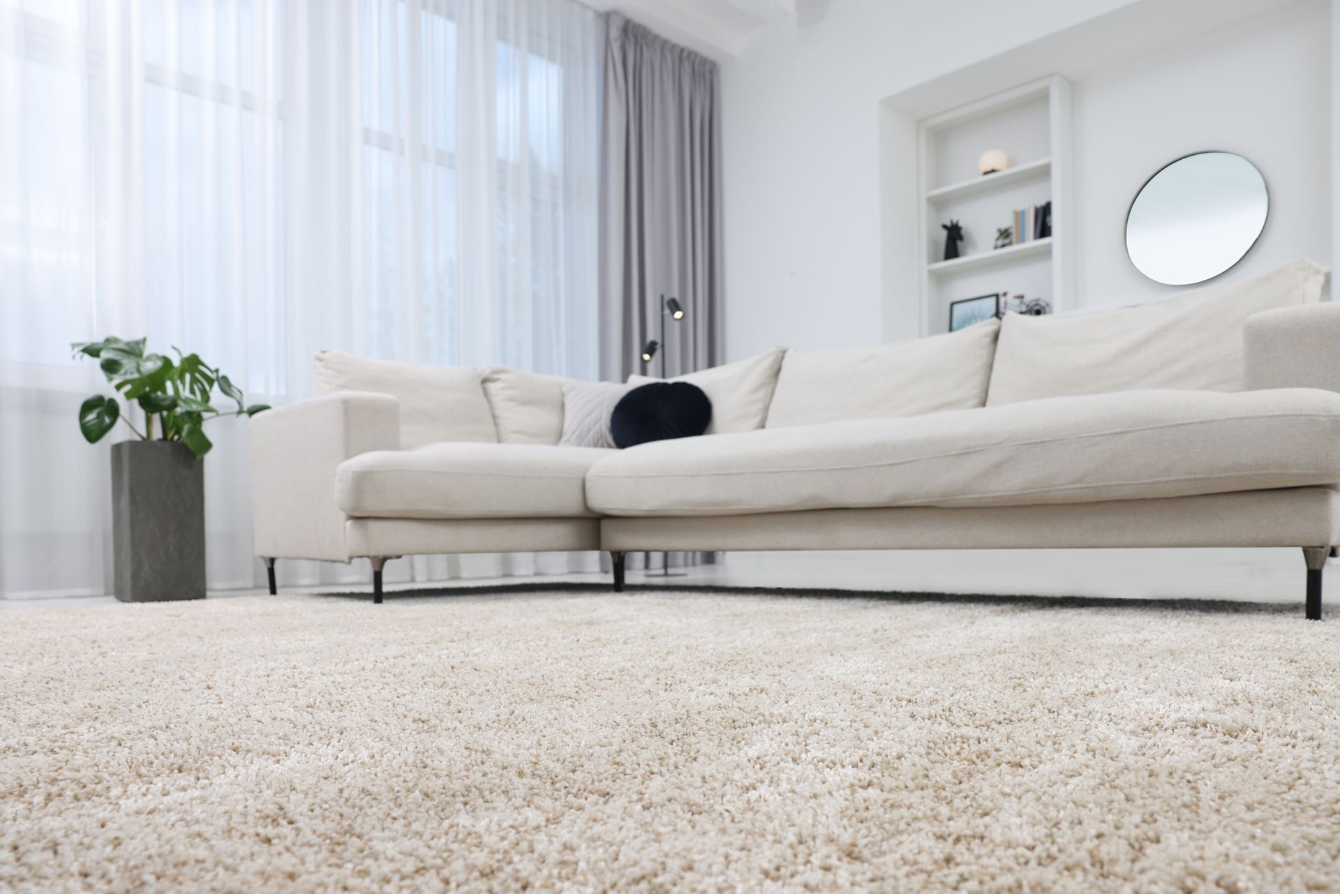 A living room with a white couch and a white carpet