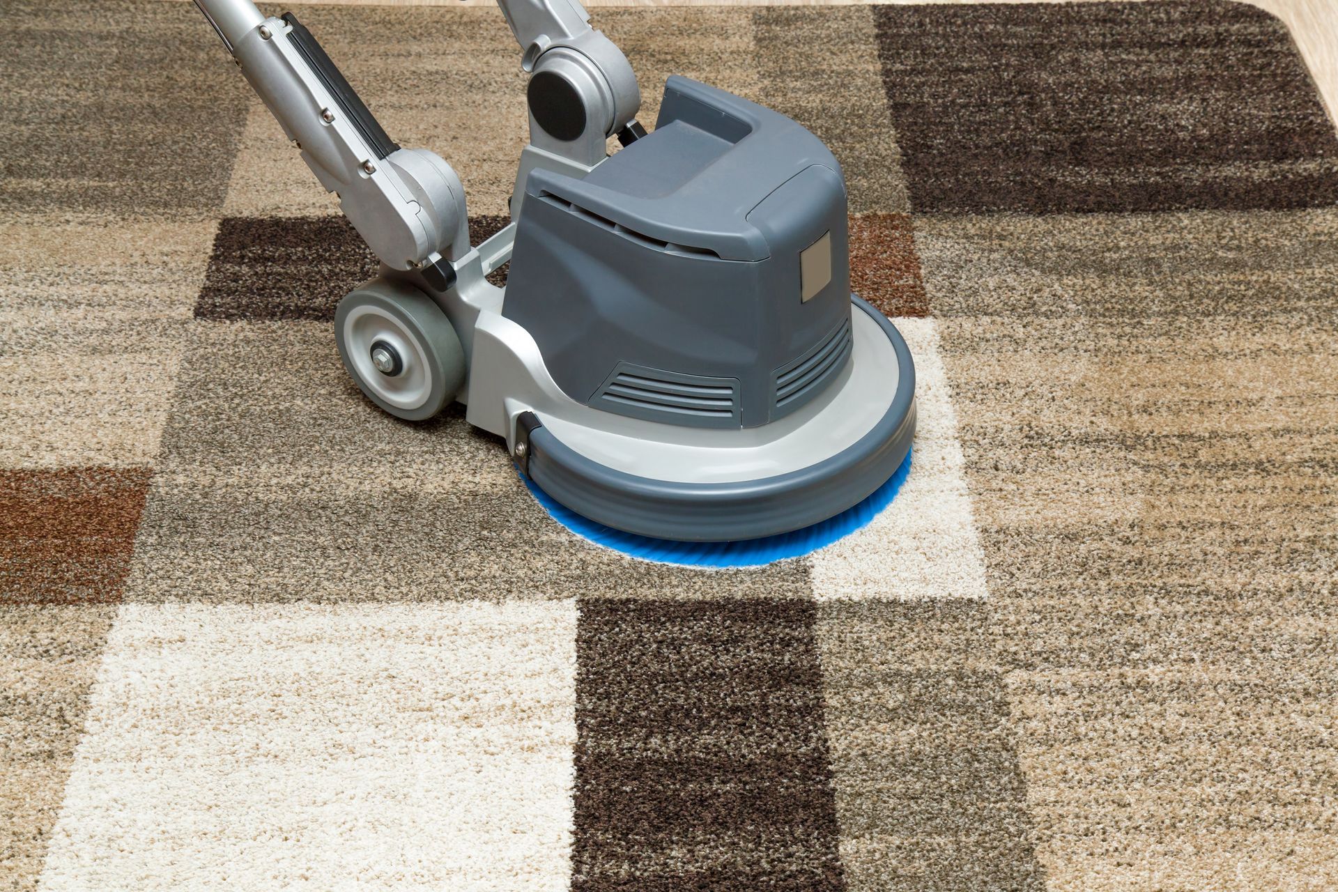 A machine is cleaning a carpet on the floor.