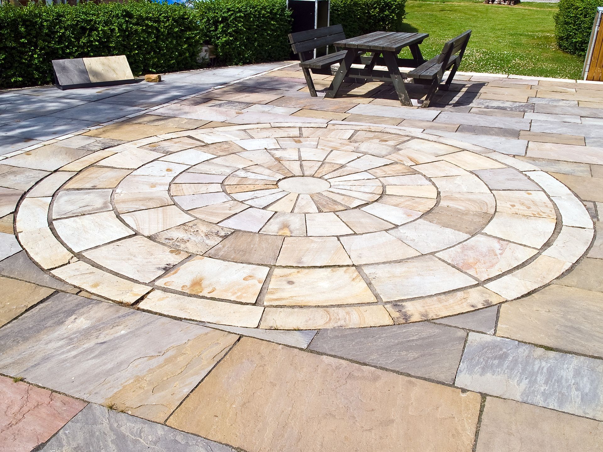 A patio with a circular design and a picnic table