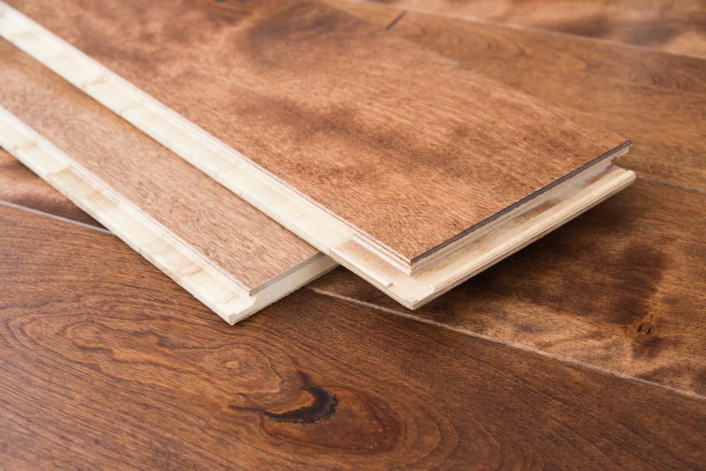 Two Pieces Of Hardwood Flooring Are Stacked On Top Of Each Other — Norm Evans Floors Pty Ltd in Nambour, QLD