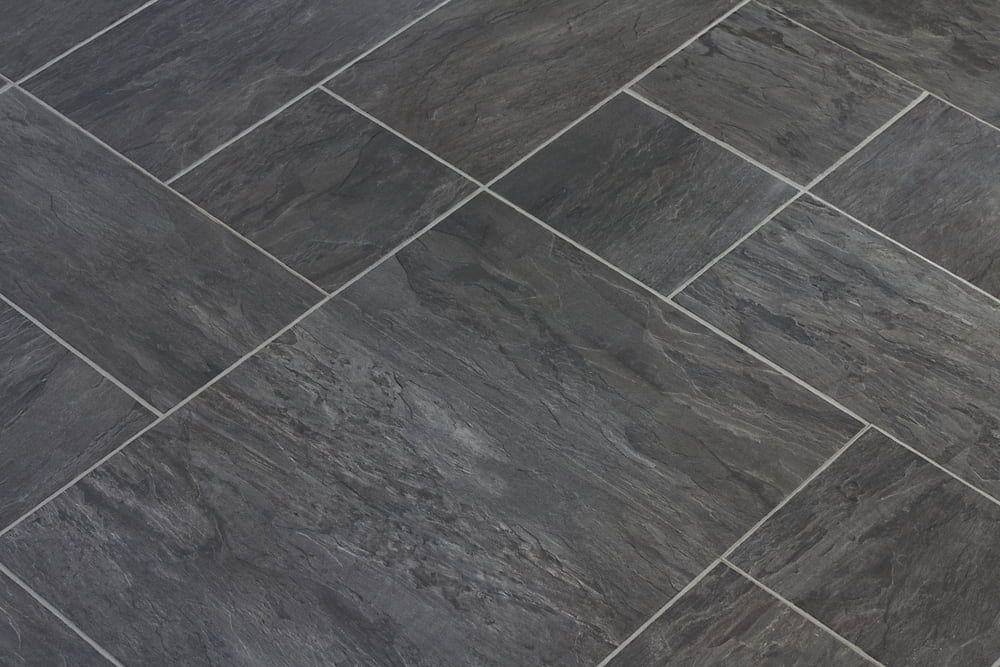 A Close Up Of A Black Tile Floor With White Grout  — Norm Evans Floors Pty Ltd in Kunda Park, QLD