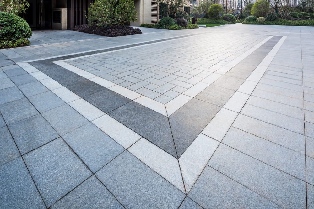 A Brick Driveway With A Geometric Pattern In The Middle Of It — Norm Evans Floors Pty Ltd in Noosa, QLD