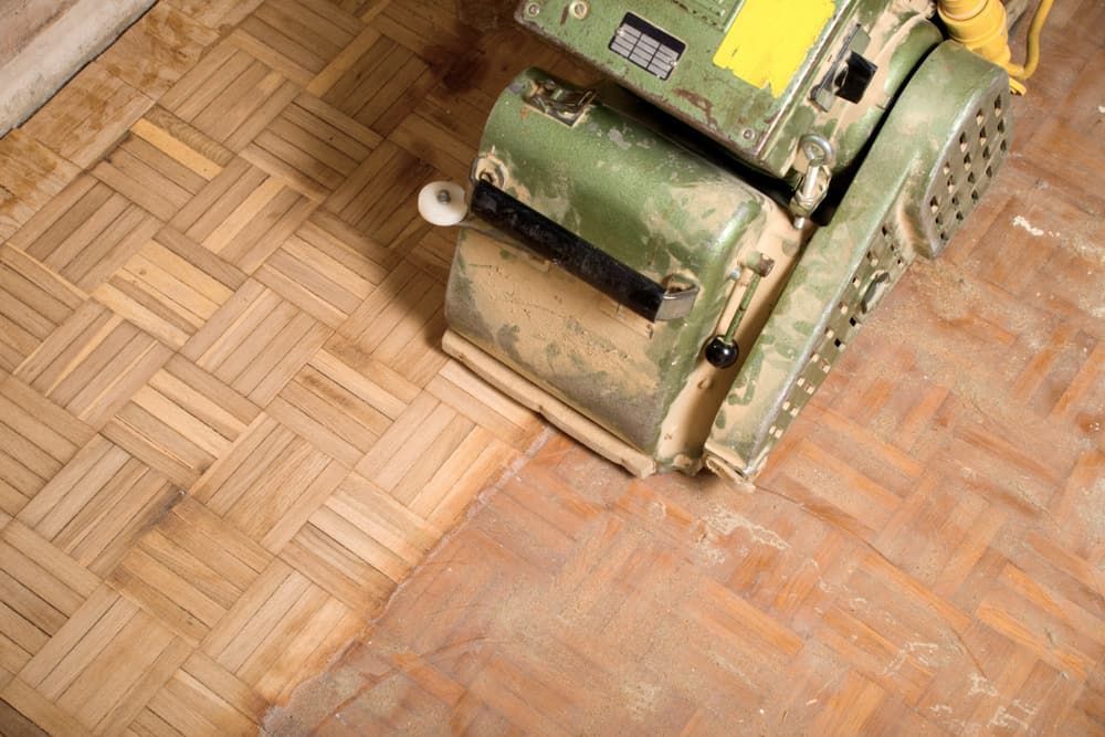 A Machine Is Sanding A Wooden Floor — Norm Evans Floors Pty Ltd in Nambour, QLD