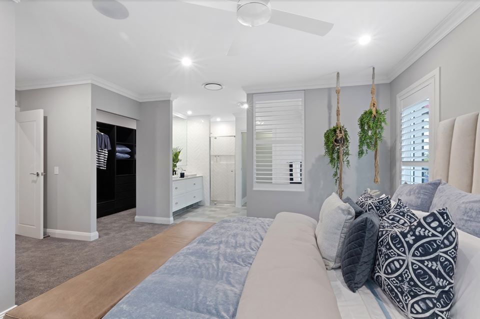 A Bedroom With A Large Bed And A Ceiling Fan  — Norm Evans Floors Pty Ltd in Kunda Park, QLD