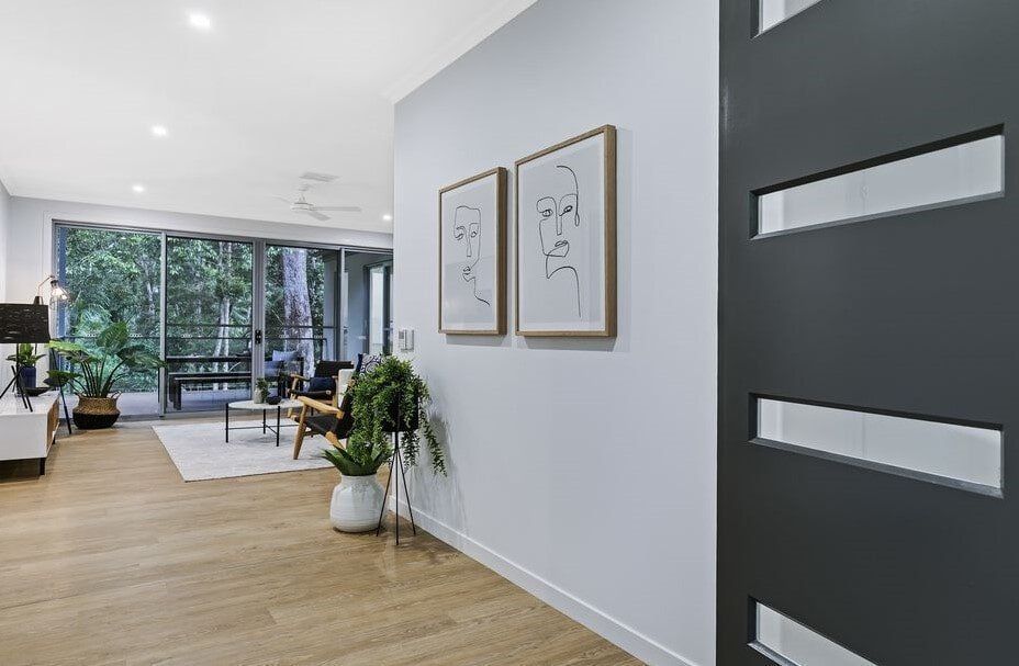 A Hallway In A House With A Black Door And Two Paintings On The Wall — Norm Evans Floors Pty Ltd in Gympie, QLD