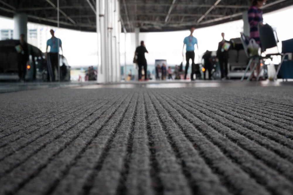 A Group of People Are Walking Through an Airport — Norm Evans Floors Pty Ltd in Nambour, QLD