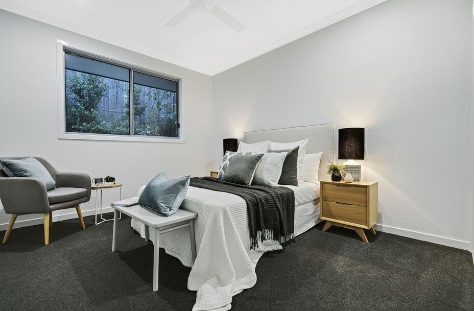 A Bedroom With A Bed , Nightstand , Chair And Window  — Norm Evans Floors Pty Ltd in Kunda Park, QLD