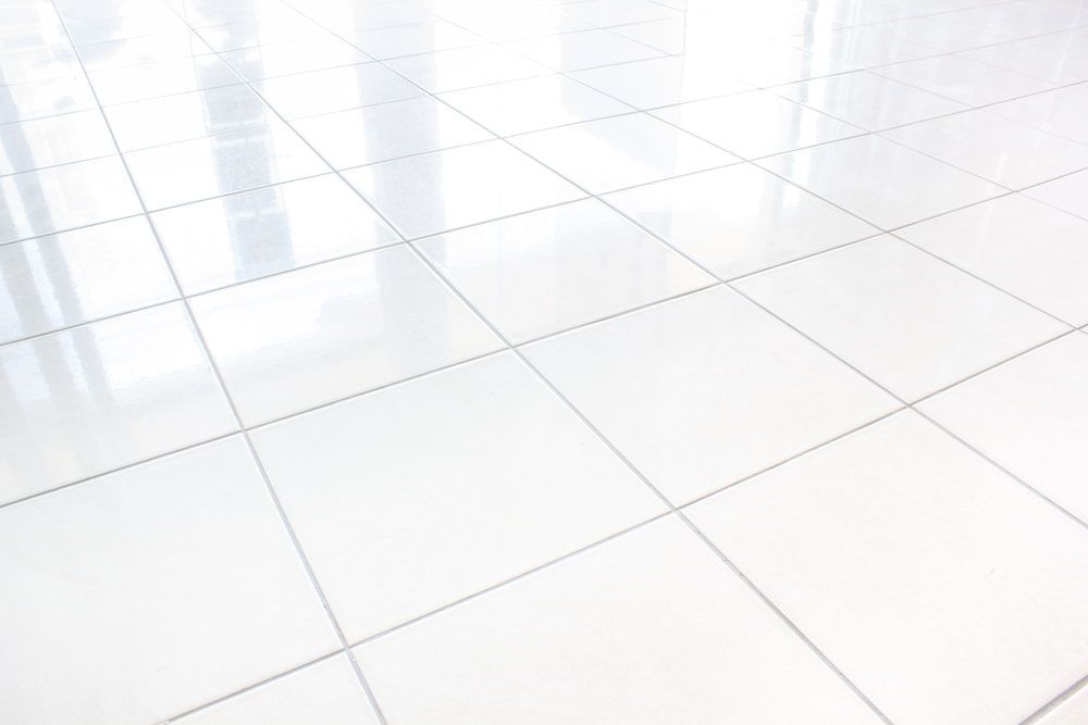 A Close Up Of A White Tiled Floor With A Reflection Of A Window — Norm Evans Floors Pty Ltd in Gympie, QLD