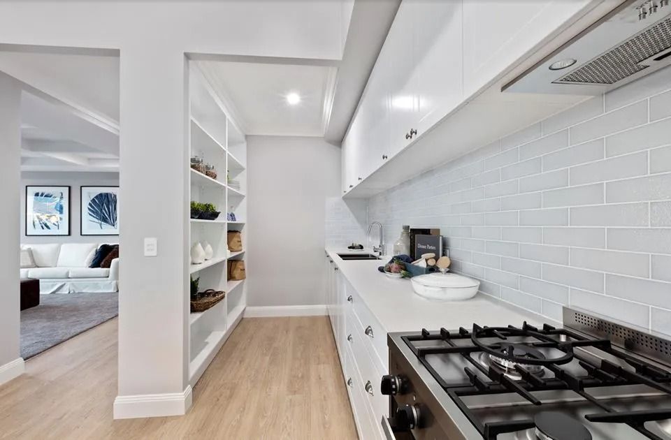 A Kitchen With White Cabinets And A Stove Top Oven  — Norm Evans Floors Pty Ltd in Kunda Park, QLD