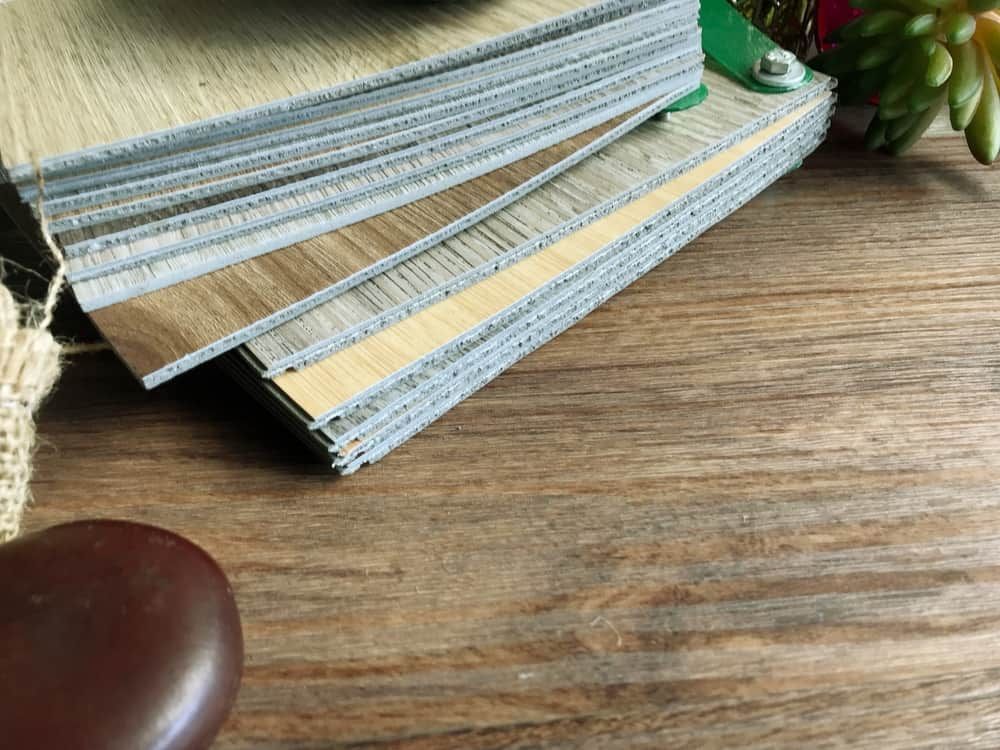 A Stack Of Wood Samples On A Wooden Table Next To A Plant — Norm Evans Floors Pty Ltd in Beerwah, QLD