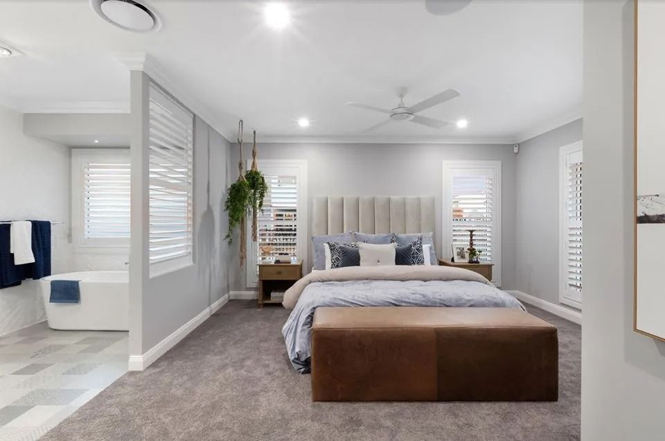 A Bedroom With A Large Bed And A Ceiling Fan  — Norm Evans Floors Pty Ltd in Kunda Park, QLD