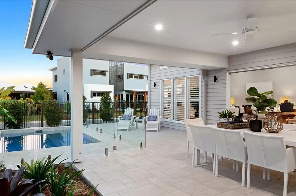 A Large Patio With A Dining Table And Chairs Next To A Pool  — Norm Evans Floors Pty Ltd in Kunda Park, QLD