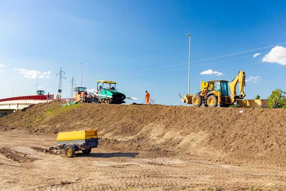 A Group Of Construction Vehicles Are Working On A Dirt Field — Hybrid Power Australia In Moranbah, QLD