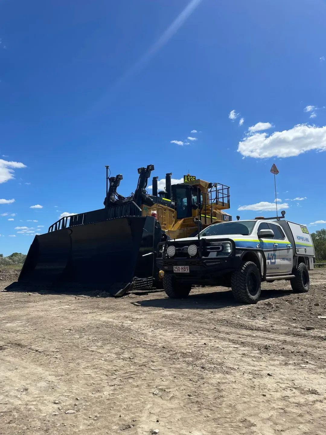 A Truck Is Parked Next To A Bulldozer In A Dirt Field — Hybrid Power Australia In Tieri, QLD