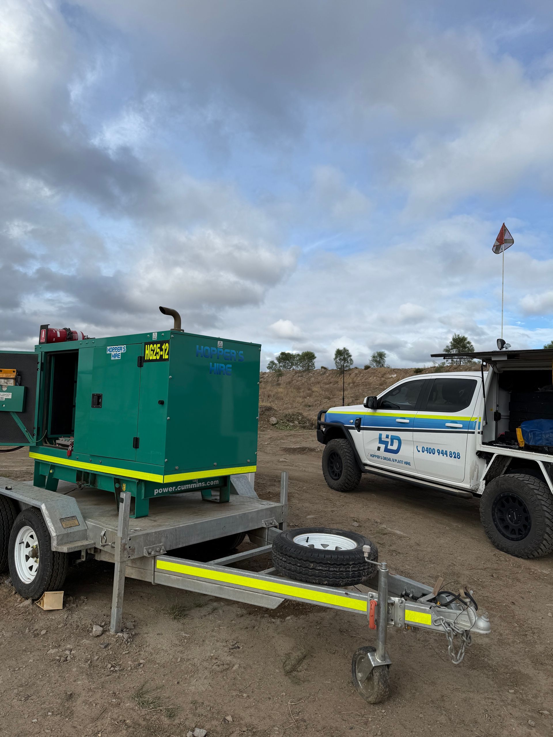A truck is parked next to a trailer with a green box on it — Hybrid Power Australia In Tieri, QLD