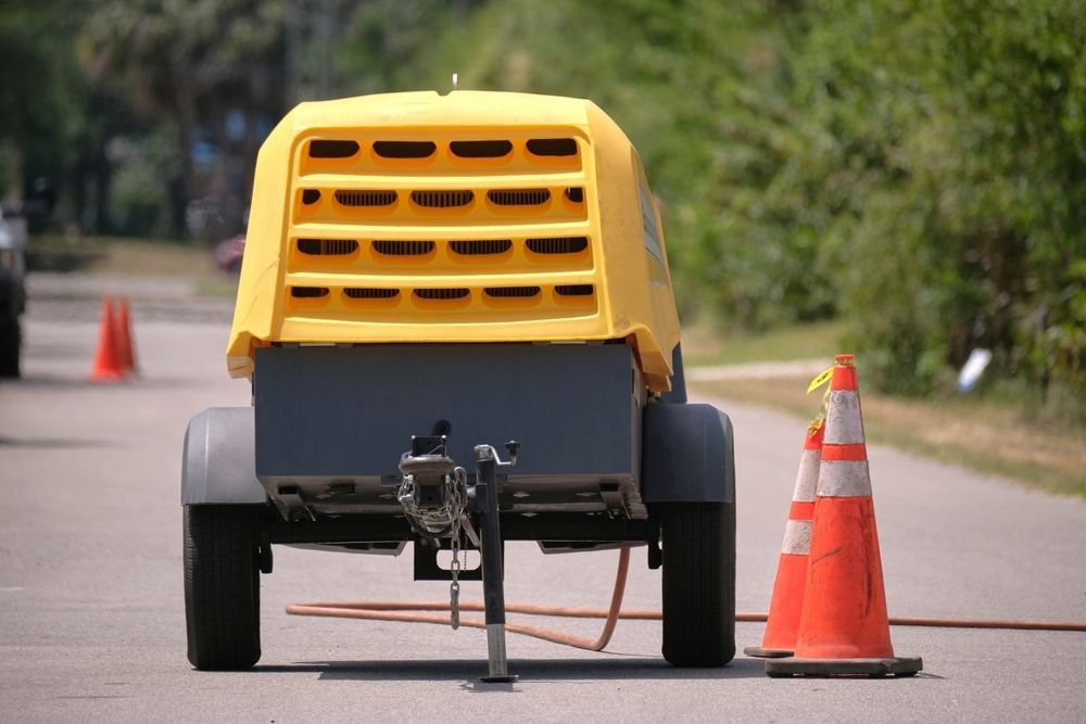 A Yellow Truck Is Parked On The Side Of The Road Next To Two Orange Cones — Hybrid Power Australia In Moranbah, QLD