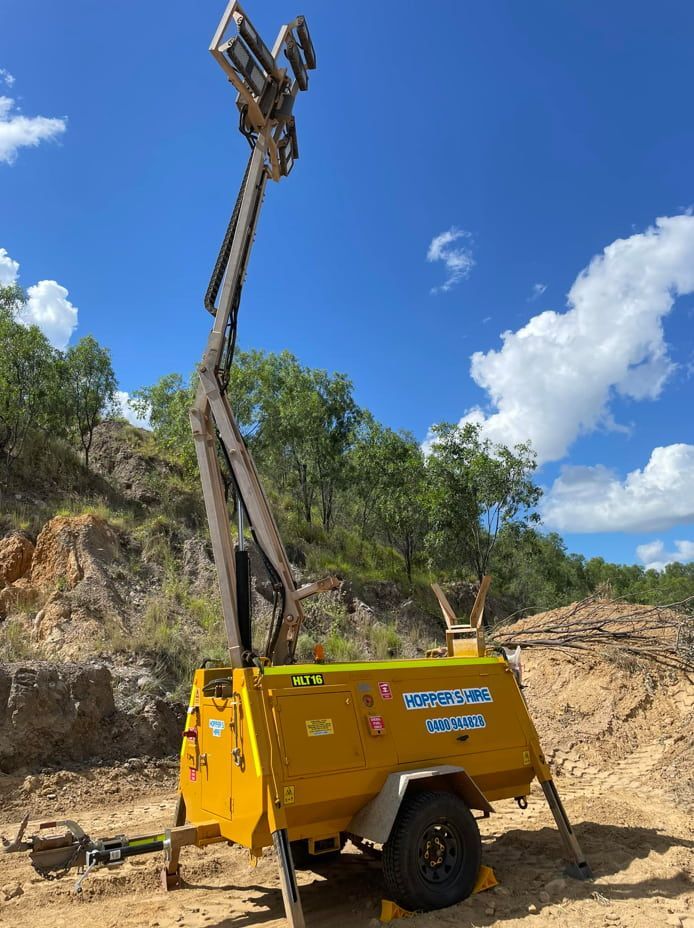 A Yellow Trailer With A Tower On Top Of It Is Parked In A Dirt Field — Hybrid Power Australia In Tieri, QLD